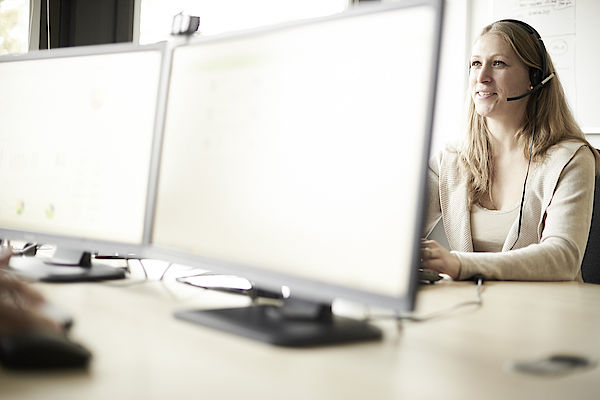 Majesty ERP software integration with estos ProCall Enterprise - woman in front of a computer with headset 